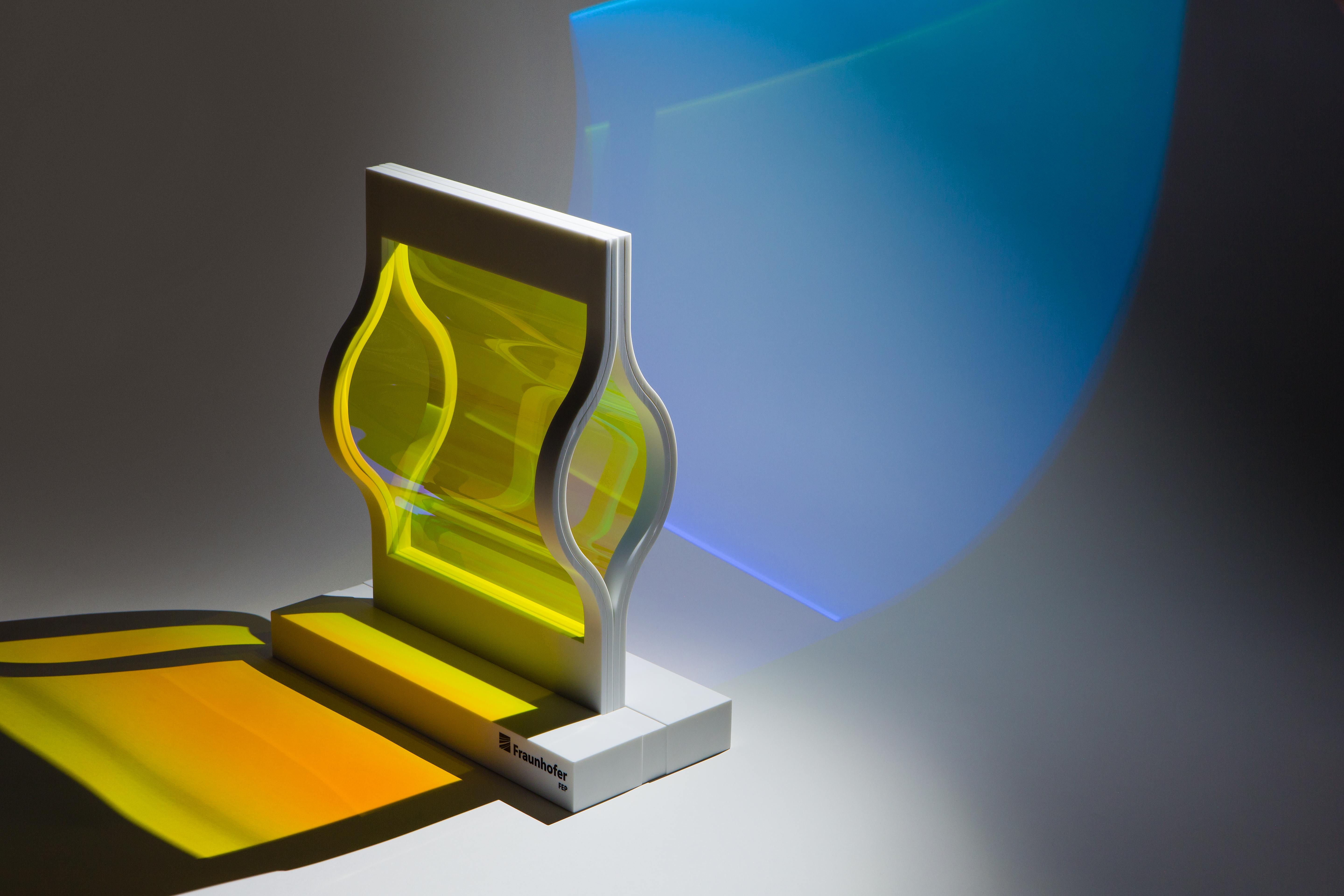 Fig. 1: Optical edge filter consisting of 20 sputtered layers on flexible thin glass, coated in a flat fixture, curved frame construction